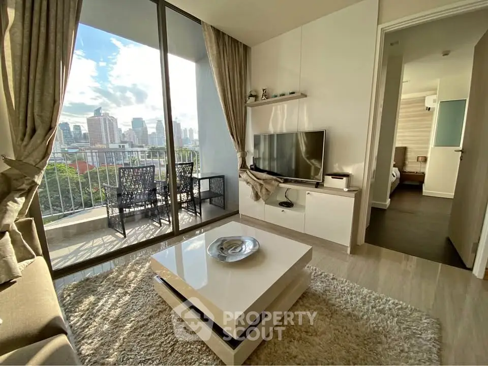 Modern living room with city view, stylish furniture, and large windows opening to a balcony.