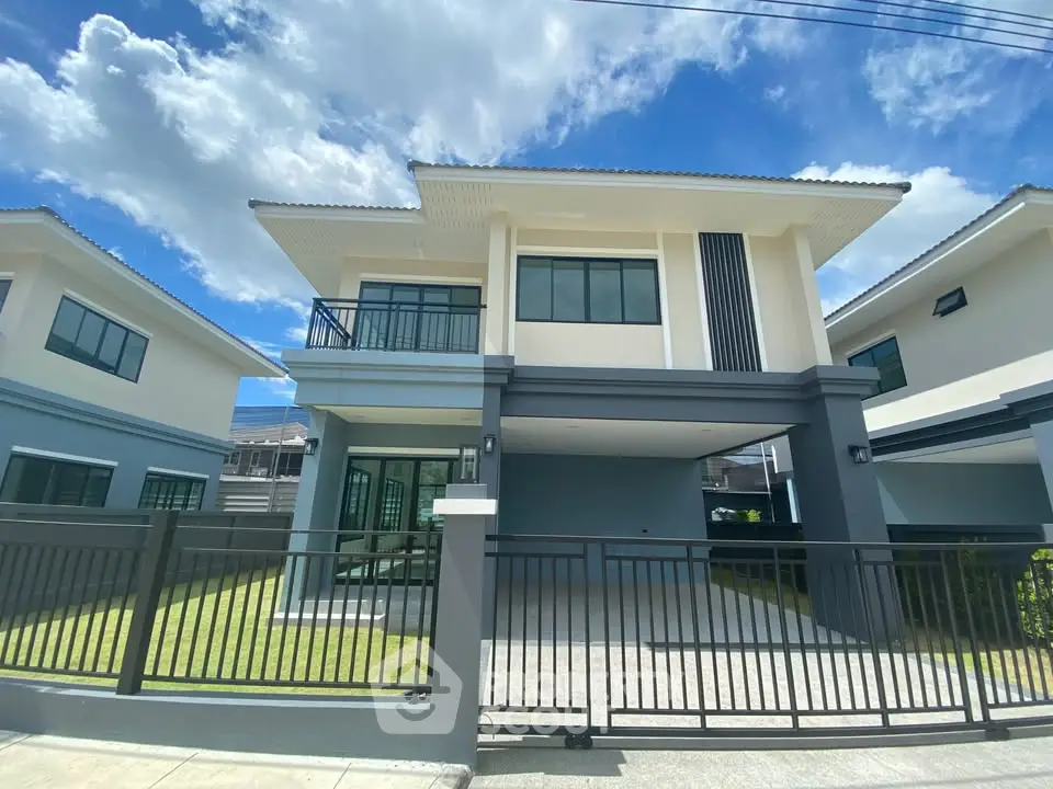 Modern two-story house with sleek design and spacious driveway under clear blue sky.