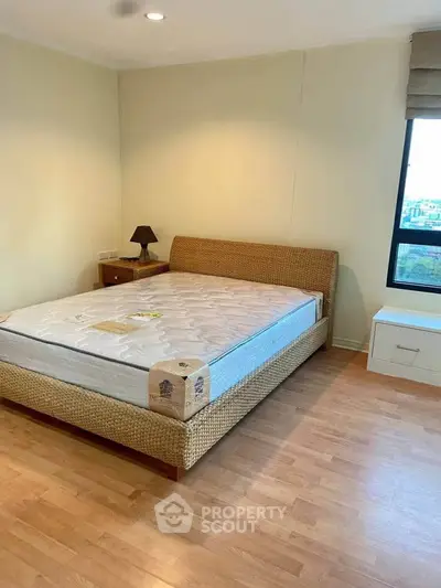 Spacious bedroom with modern wicker bed and hardwood floors