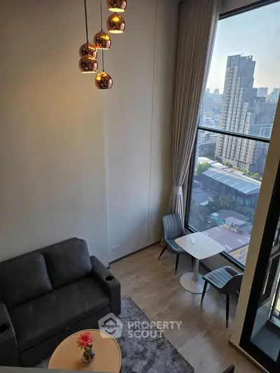 Modern living room with high ceiling and city view, featuring stylish lighting and cozy seating area.