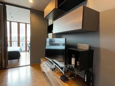 Modern living room with sleek TV setup and view into bedroom