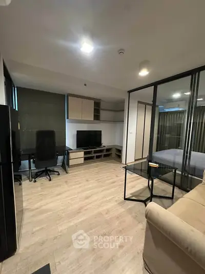 Modern living room with sleek furniture and glass partition in stylish apartment.