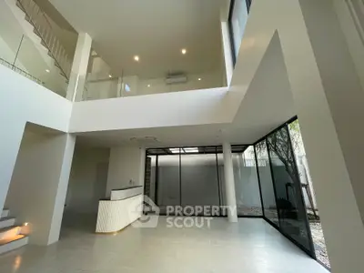 Spacious modern interior with high ceilings and large windows, perfect for natural light.