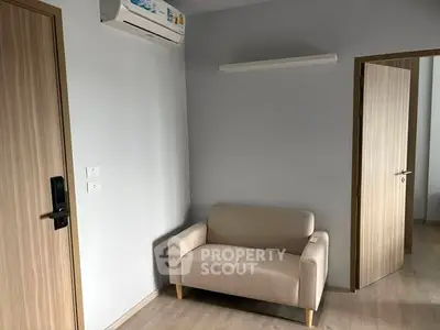 Modern minimalist living room with beige sofa and air conditioning unit.