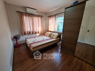 Cozy bedroom with wooden flooring and natural light