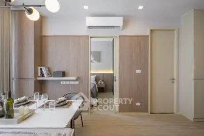 Modern dining area with elegant table setting and view into cozy bedroom