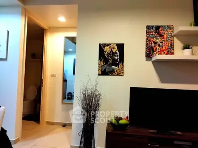 Stylish living room with modern decor and wall art, featuring a glimpse into a bathroom.