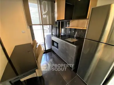 Modern kitchen with sleek appliances and dining area in a stylish apartment.