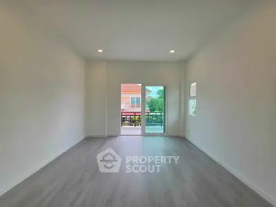 Spacious empty living room with large windows and balcony access, perfect for customization.