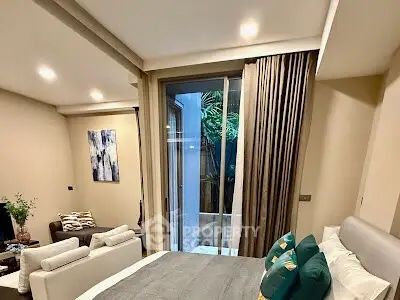 Cozy bedroom with modern decor and large window overlooking a small courtyard.