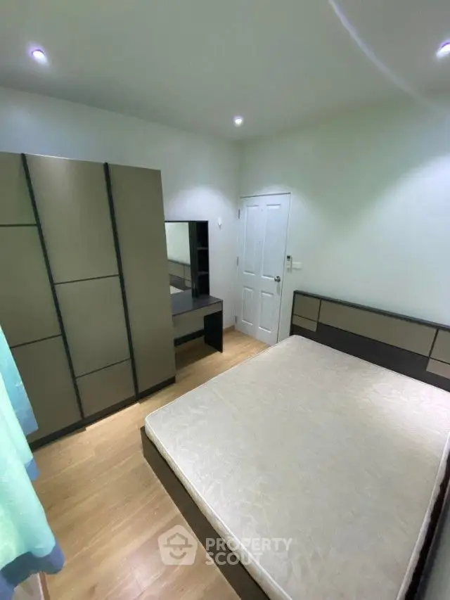 Spacious bedroom with modern furnishings, large mirrored wardrobe, and ambient lighting, perfect for a restful retreat in a contemporary home.