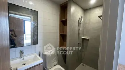 Modern bathroom with sleek shower and stylish sink in contemporary apartment.