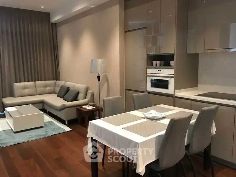 Modern open-plan living room and kitchen with elegant dining area and cozy seating.
