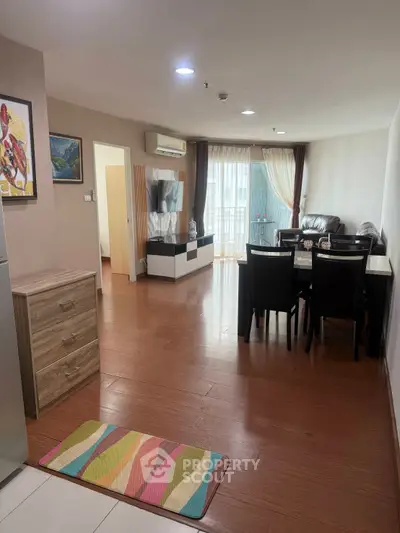 Spacious living room with modern furniture and natural light in a stylish apartment.