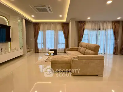Spacious modern living room with elegant beige sofa and floor-to-ceiling windows