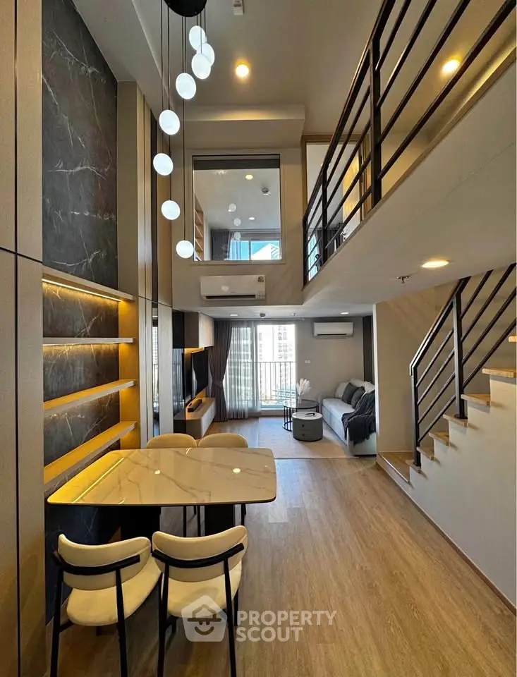 Stunning modern duplex with high ceilings and elegant lighting in a spacious living area.