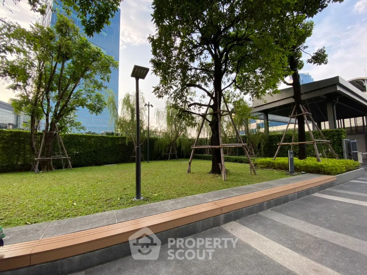 Spacious urban garden with lush greenery and modern architecture, perfect for relaxation and outdoor activities.