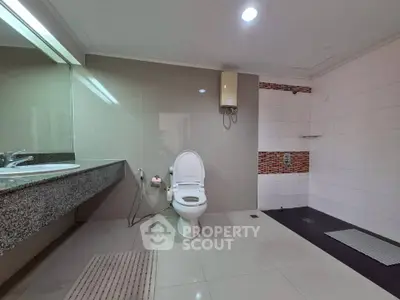 Spacious modern bathroom with sleek fixtures and large mirror, ideal for comfort and style.
