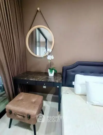 Stylish bedroom with elegant decor and modern furniture, featuring a chic vanity and plush seating.