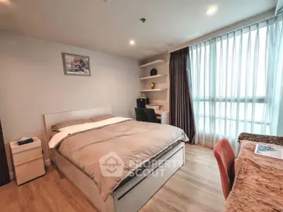 Cozy bedroom with modern decor, featuring a comfortable bed, study desk, and large window for natural light.