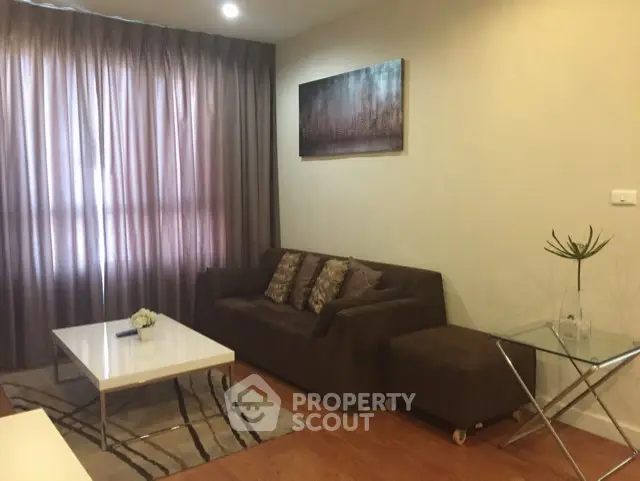 Cozy living room with modern decor, brown sofa, and elegant curtains.