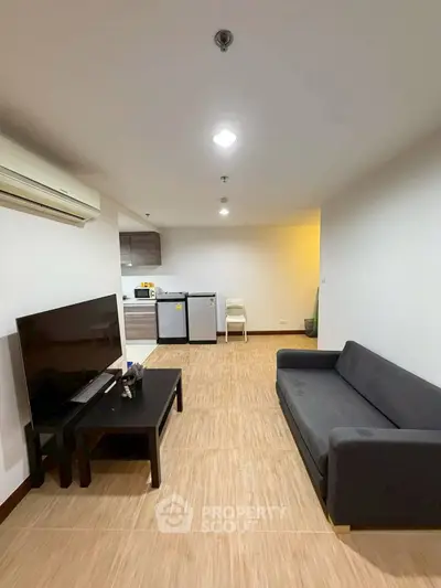 Modern living room with sleek furniture and open kitchen layout, perfect for urban living.