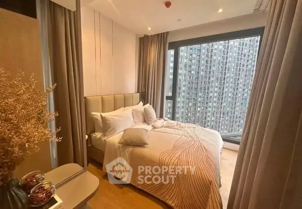 Modern bedroom with large window offering stunning city view in high-rise apartment.