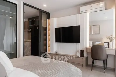 Modern bedroom with sleek design, featuring a wall-mounted TV and stylish workspace.