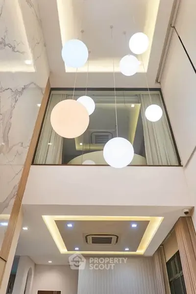 Modern interior with high ceiling and stylish lighting fixtures