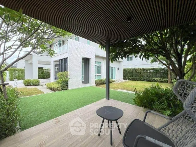 Modern house with lush garden and cozy patio seating area