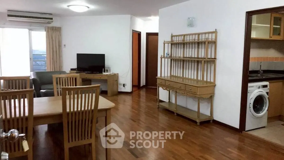 Spacious living room with dining area and modern appliances in a stylish apartment.
