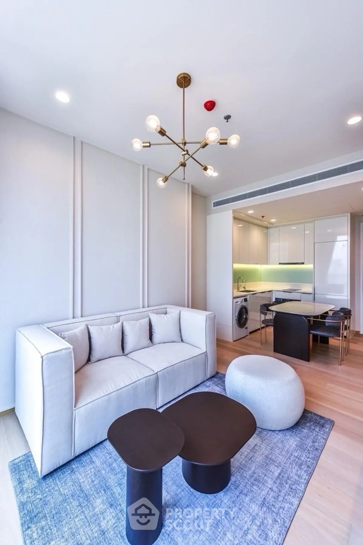 Modern living room with stylish furniture and open kitchen layout in a contemporary apartment.