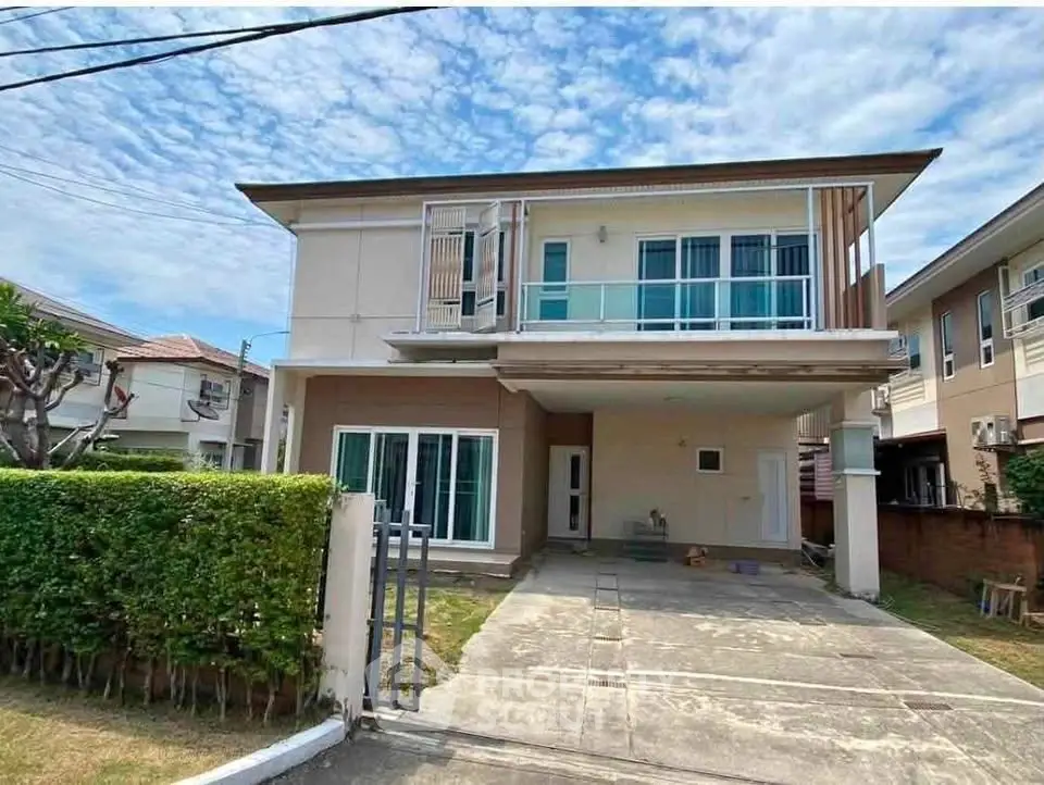 Modern two-story house with spacious driveway and manicured hedge in suburban neighborhood.
