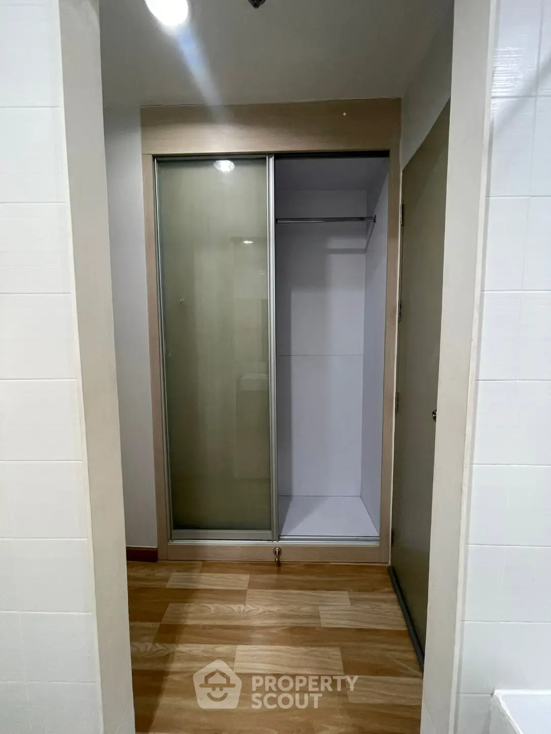 Spacious walk-in closet with sliding doors and wooden flooring