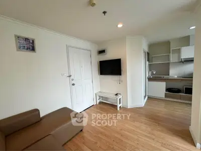 Modern living room with open kitchen layout and sleek wooden flooring