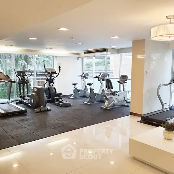 Modern gym with state-of-the-art fitness equipment and large windows offering natural light.