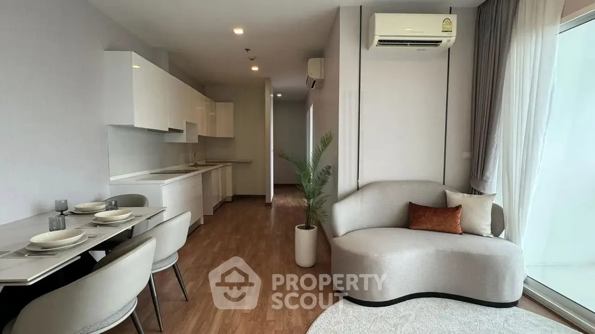 Modern open-plan living room with stylish furniture and sleek kitchen design.