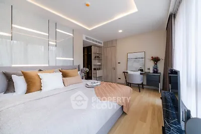 Luxurious bedroom with elegant decor and natural light, featuring a cozy study nook.