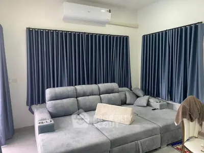 Spacious living room with modern gray sectional sofa and elegant blue curtains.