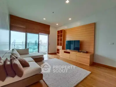 Spacious living room with city view, modern furniture, and wooden accents in a high-rise apartment.