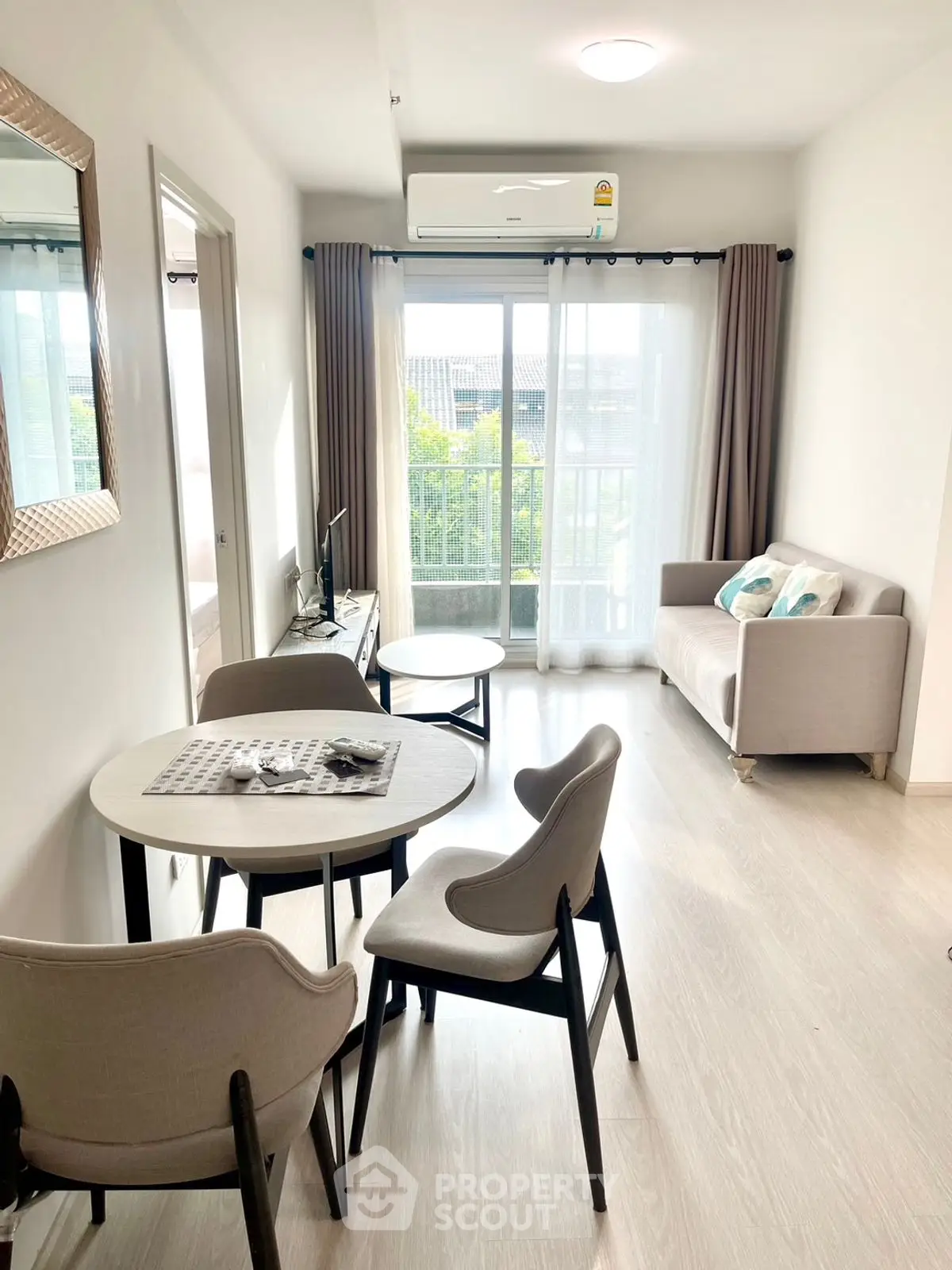 Bright and modern living room with balcony view, stylish furniture, and ample natural light.