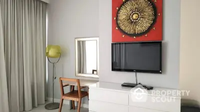 Modern bedroom with stylish decor, featuring a TV, dresser, and unique wall art.