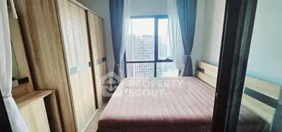 Modern bedroom with large window and city view, featuring stylish wooden furniture and elegant curtains.