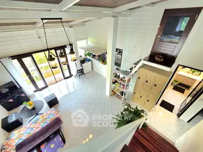 Spacious open-plan living room with modern decor and large windows for natural light.