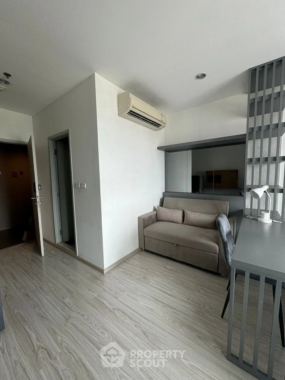Modern living room with sleek design and neutral tones, featuring a comfortable sofa and stylish decor.