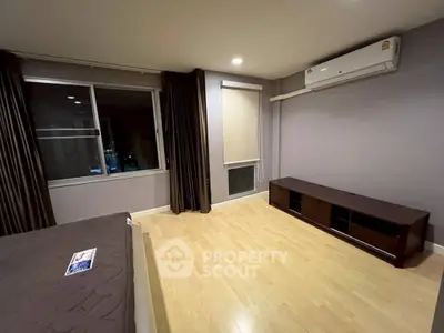 Spacious bedroom with modern air conditioning and wooden flooring