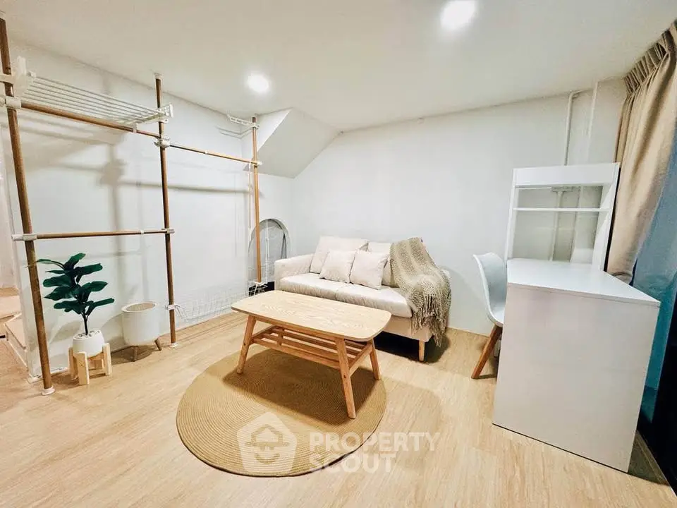 Cozy living room with modern decor and natural light, featuring a stylish sofa and workspace.