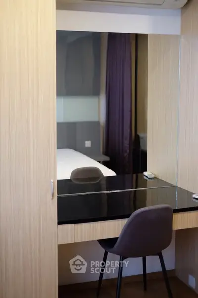 Modern bedroom with sleek vanity and comfortable chair, perfect for stylish living.