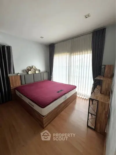 Spacious bedroom with modern decor and large window for natural light