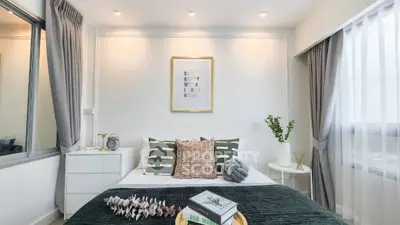 Modern bedroom with stylish decor, large windows, and cozy ambiance in a contemporary apartment.